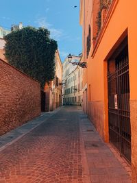 Footpath amidst buildings against sky