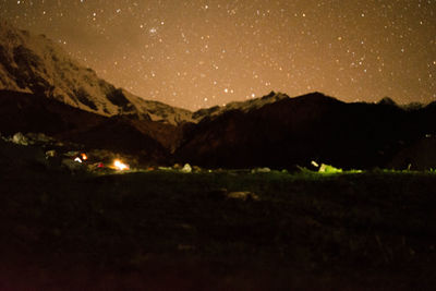 Scenic view of illuminated mountains against sky at night