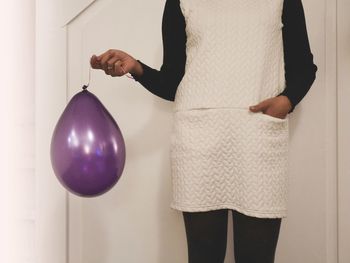 Midsection of woman with balloons at home