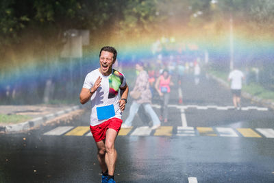 Full length of man running on road during rainfall