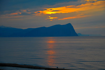 Scenic view of sea and mountains during sunset