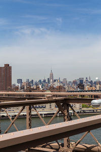 Bridge over river in city against sky