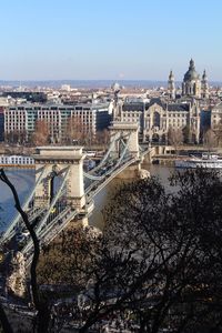 Bridge over river against buildings in city