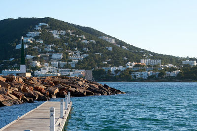 Scenic view of sea by town against clear sky