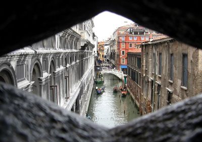 Scenic view boats in canal flanked by buildings