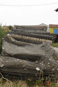 Stack of logs on field against clear sky