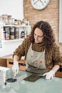 Woman artist preparing ink for an art print. using an ink stick