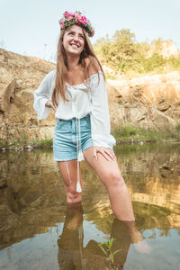 Portrait of smiling young woman standing in lake