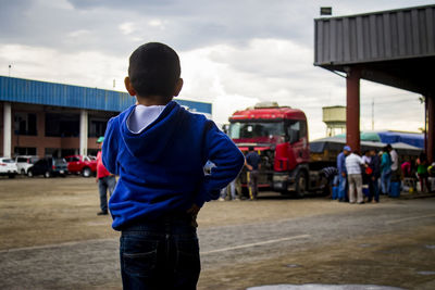 Rear view of boy standing at street