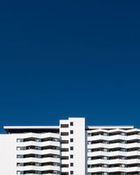 Low angle view of modern building against clear blue sky