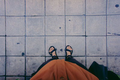 Low section of man standing on tiled floor