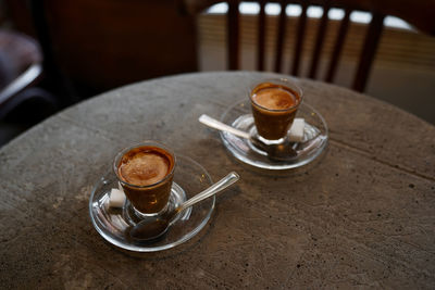 Two cups of espresso on grey concrete table