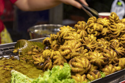 Whole octopus, small size, grilled with sauce until golden. appetizing. big piles on banana leaves 