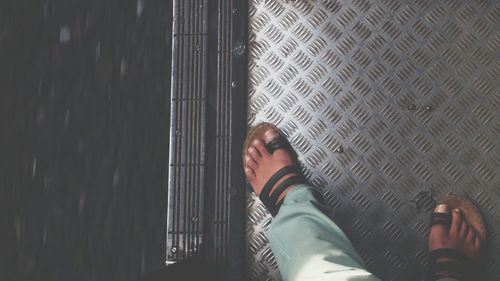 Low section of man standing in train