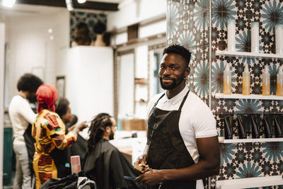 Portrait of male hairdresser standing in barber shop