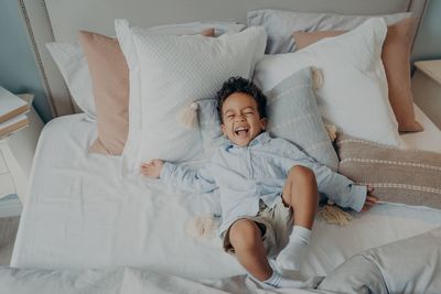 High angle view of boy relaxing on bed at home