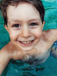 Portrait of happy boy swimming in pool