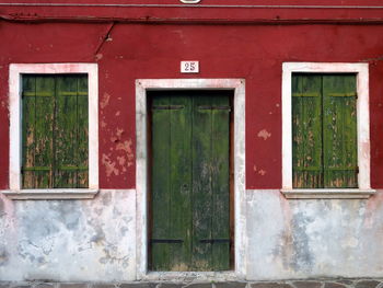 Green door and windows on red wall