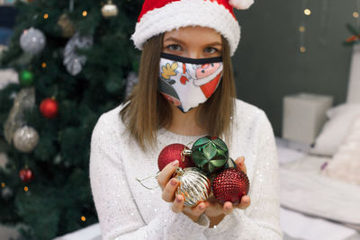 Portrait of woman holding christmas tree