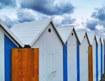 Wooden posts on beach against sky