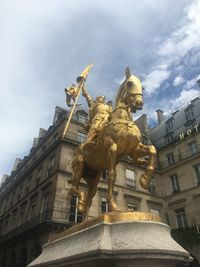 Low angle view of statue against sky in city