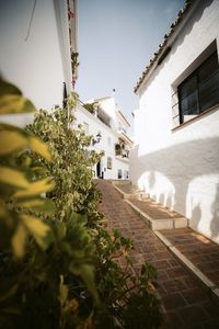 Street amidst houses and buildings against sky