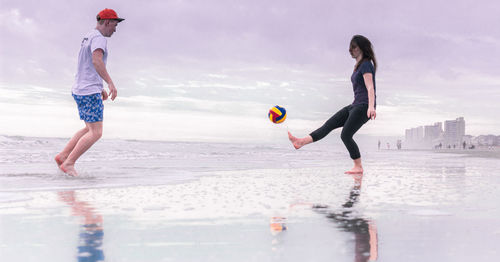 Full length of man playing in sea against sky