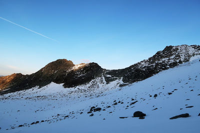 Scenic view of snowcapped mountains against clear blue sky