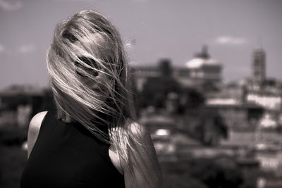 Close-up of woman standing against sky in city