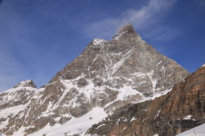 Low angle view of snowcapped mountain against sky