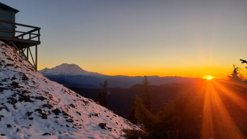 Scenic view of snowcapped mountains against sky during sunset