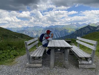 Man sitting on seat against mountains