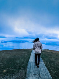 Rear view of woman looking at sea against sky