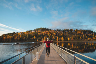 Autumn sunset at lake syvajarvi, in hyrynsalmi, finland. a young man in a plaid red and black shirt