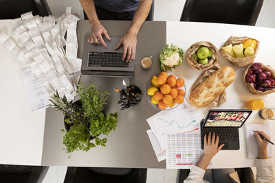 High angle view of people using laptops in kitchen