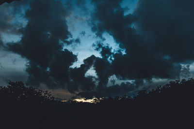 Silhouette of trees against cloudy sky