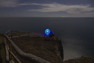 Illuminated sphere on seashore