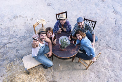 High angle portrait of happy friends sitting in yard