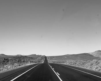 Road leading towards mountain against sky