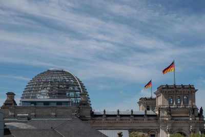 German flags on building against sky in city