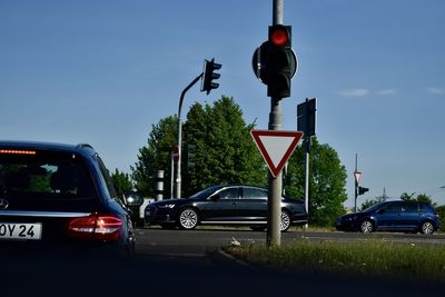 Cars on street in city against sky