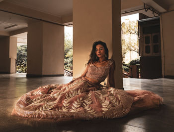 Portrait of young woman sitting on floor at home