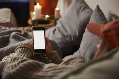 Woman lying in bed and using phone