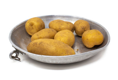 Close-up of fruits in plate against white background