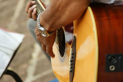 Midsection of man playing guitar