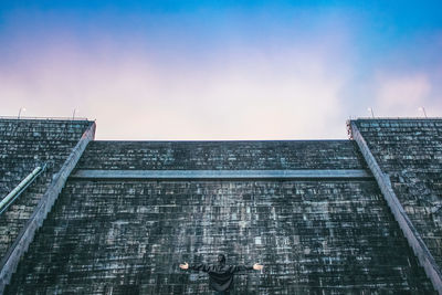 Rear view of man standing against built structure