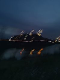 Scenic view of lake by trees against sky at night