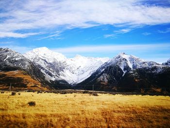 Scenic view of snowcapped mountain against cloudy sky