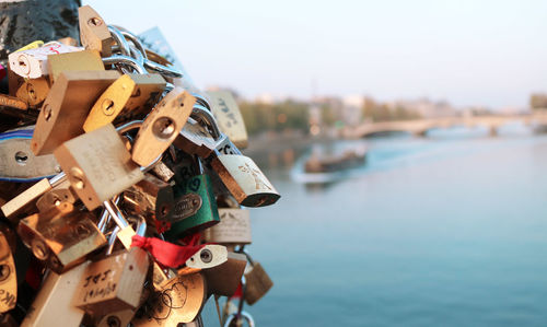 Close-up of padlocks on bridge against sky