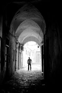 Rear view of man walking in tunnel
